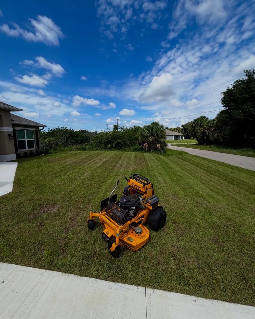 Moore Precision commercial zero-turn mower on a freshly striped North Port lawn