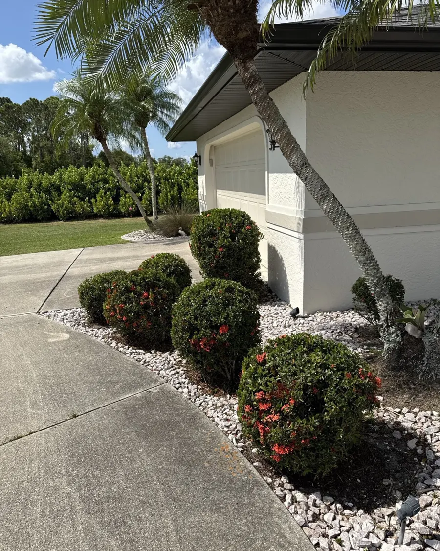 Trimmed shrubs and rock border along a curved walkway